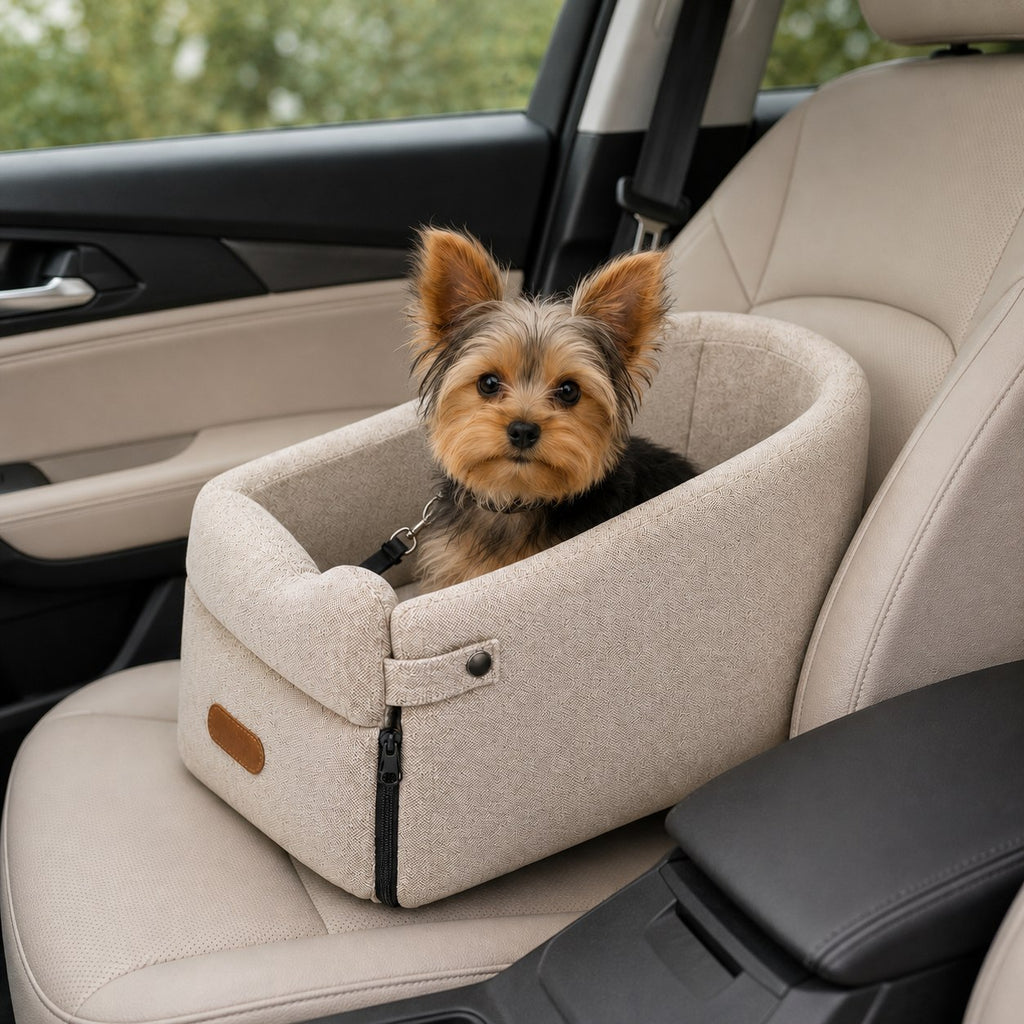 Yorkshire terrier zit in het beige autostoeltje op de passagiersstoel